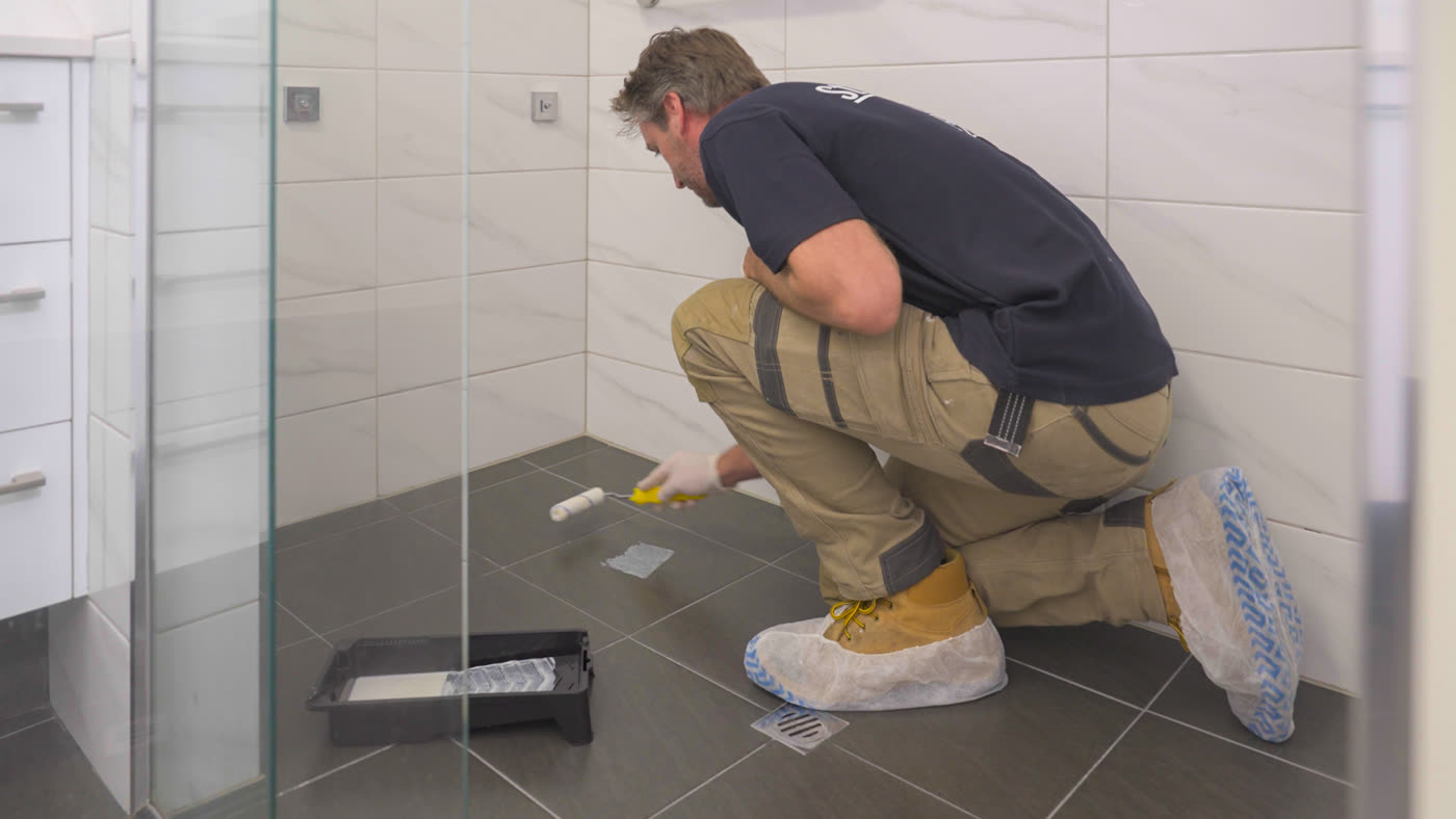 Non-slip surface treatment being applied to a tiled shower floor
